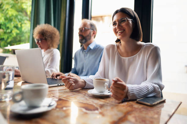 istock Young businesswoman talking with her colleagues while drinking coffee at the restaurant 1281355822