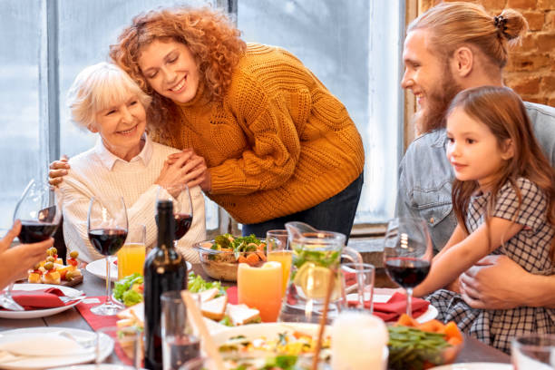 istock Happy woman hugging her granny standing near dining table 1281355970