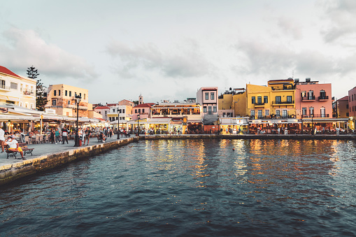 Waterfront in Chania, Crete right before sunset. Colorful buildings and busy streets of Chania, full of people, despite the pandemic.