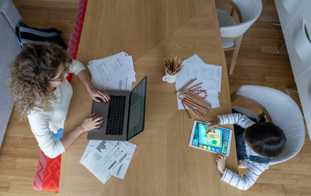 istock Boy playing games on a tablet while his mother is working at home 1281357177