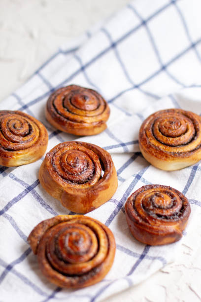 istock baked cinnamon buns on light background with checkered napkin 1281360733