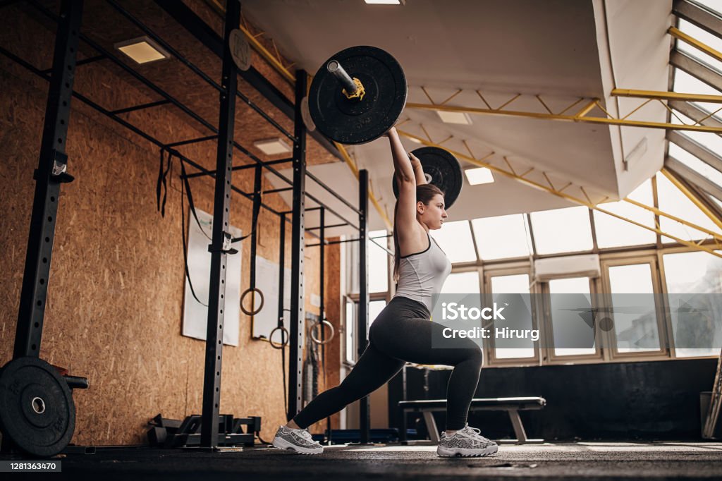 Fit woman training with weights in gym One woman, fit woman training with weights in gym. Weightlifting Stock Photo