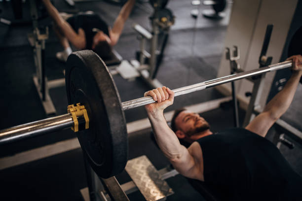 istock Fit man training on bench press in gym 1281364976