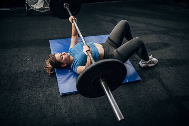 istock Strong woman training with weights on the floor in gym 1281365111