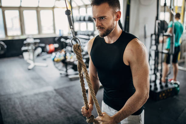 istock Fit man exercising with rope in gym 1281365922