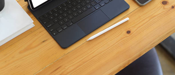 istock Wooden table with tablet, keyboard, stylus and copy space 1281367275