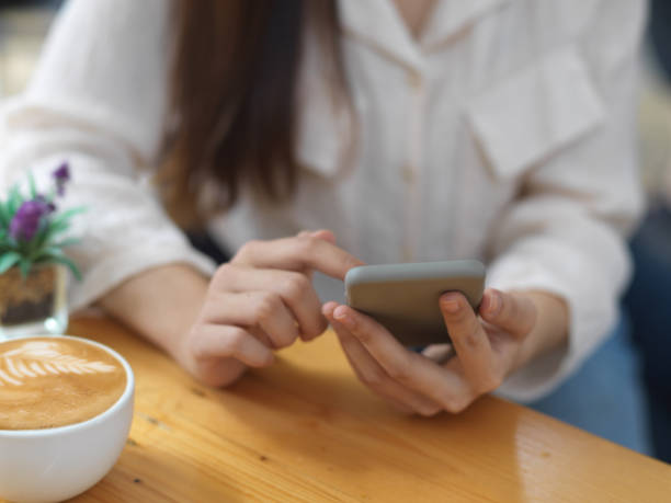 istock Female using smartphone while relaxing sitting with coffee cup in cafe 1281369130