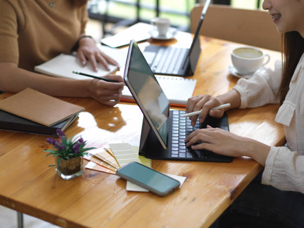 istock Two female students doing their group project with digital tablets and stationery 1281369151