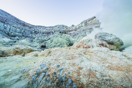 Sulfur lake and smoking mine mountain in the morning at Kawah Ijen volcano East Java Indonesia