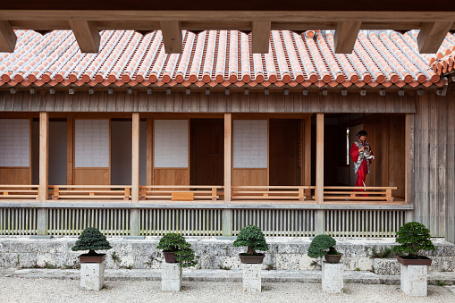 February/23/2011 Outside the Shuri castle grounds at a traditional Okinawan styled tea house a woman is seen walking out from a room dressed in traditional wear with a tea pot. Okinawa, Japan