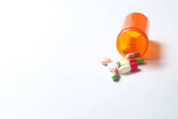 istock many colorful pills and capsules spilling form a container on white background 1281372272