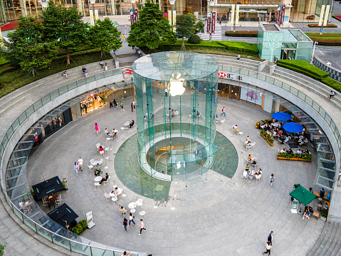 Shanghai, China - Sep 27, 2020: Apple store in downtown Lujiazui financial district during coronavirus period. Drone aerial view of shopping mall people wearing face masks. Finance business concept