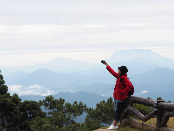 istock tourist enjoying over mountain view with fog background 1281376997