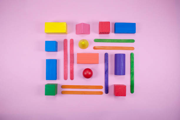 Minimalist composition of geometrical shapes on flat surface. Different shapes with different colors. Kids wooden toys.