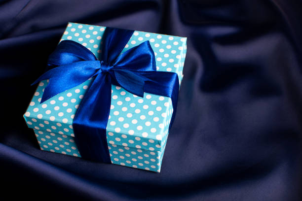 istock Blue gift box with a bow on a blue background. Holiday greeting card. 1281380950