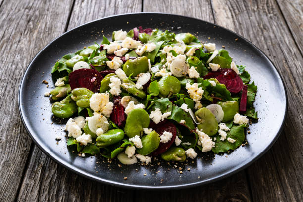 istock Beetroot salad with broad bean and goat cheese on wooden background 1281381666