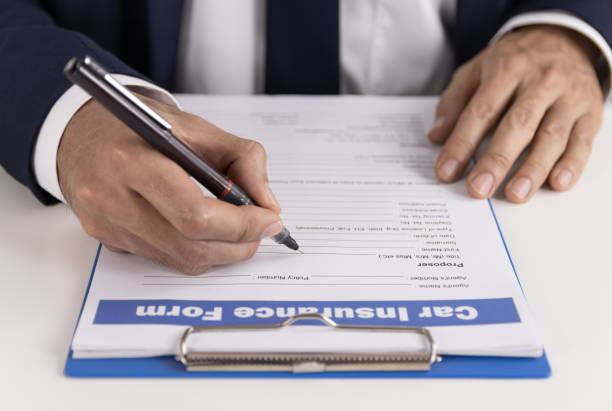 istock Insurance Agent Hand Writing Car Insurance Claim Form or Document 1281385526
