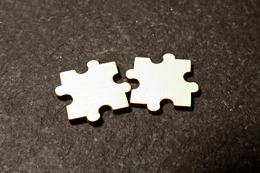 Two pieces of white puzzle and fitting them together concept for solution or partnership