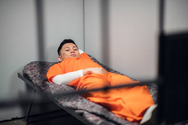 istock Asian killer sentenced to a long prison term lies on a bunk in a high-security colony in a cell behind bars 1281387837