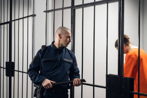 A uniformed overseer in an asian prison makes an evening tour of the cells with prisoners stock photo