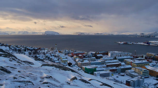 冬の午後の太陽の下で雪に覆われた山々と北極海の海岸に位置ハンメルフェストの中心の空中写真。 - hammerfest ストックフォトと画像