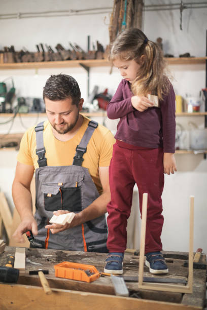 istock Father and daughter making wooden frame in workshop 1281394871