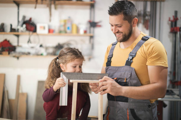 istock Father and daughter making wooden frame in workshop 1281395893