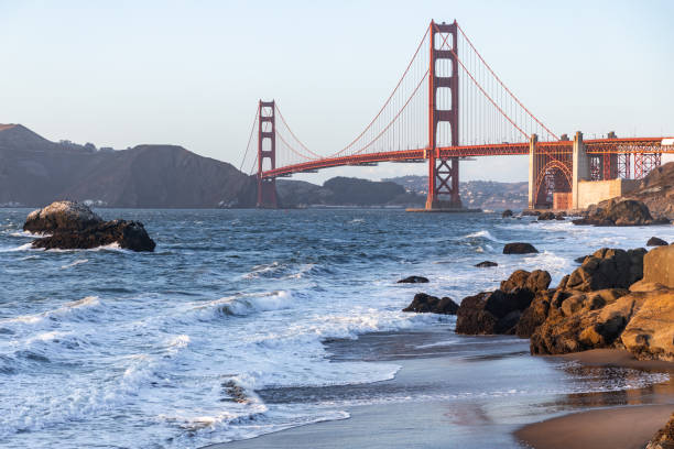 istock Golden gate bridge with strong wave hit rocks at Baker beach. 1281396036