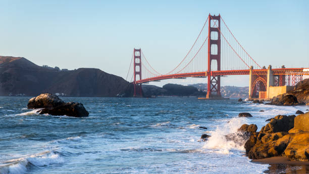 istock Golden gate bridge with strong wave hit rocks at Baker beach. 1281396603