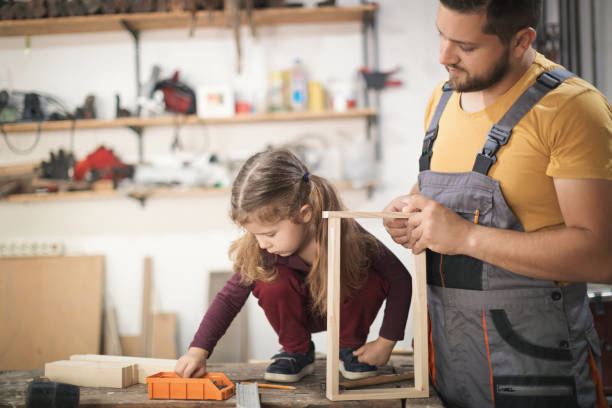 istock Father and daughter making wooden frame in workshop 1281396720