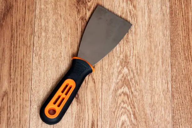 Photo of Paint spatula with black handle on wooden background