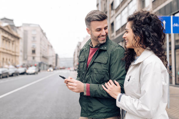 istock Couple on vacation walking and using smartphone through the city 1281397755