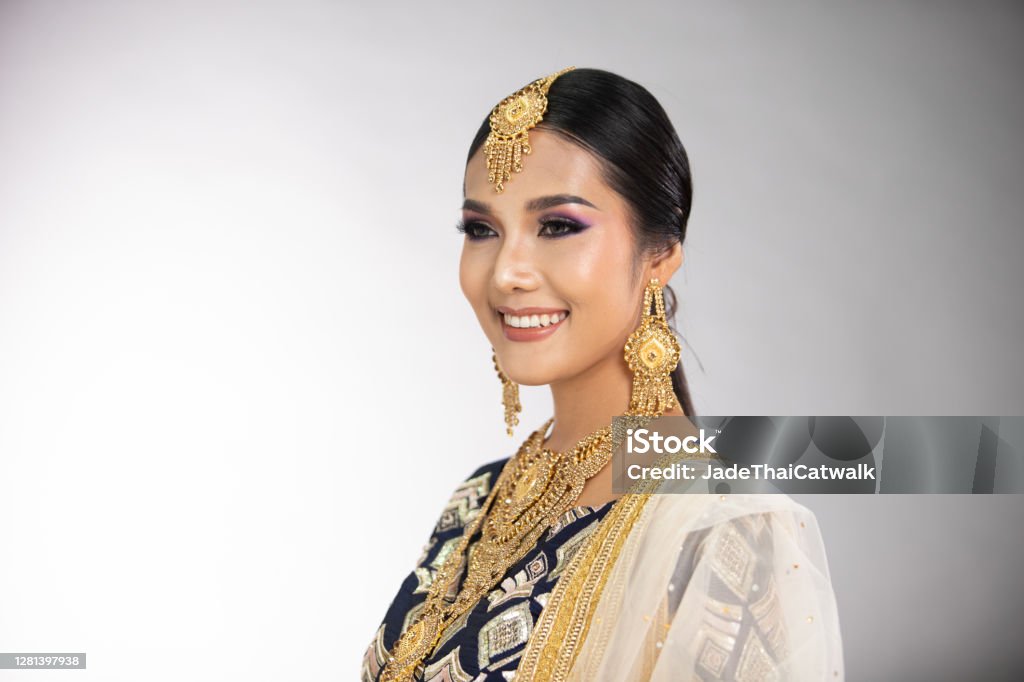 Indian beautiful bridal woman wear Traditional wedding dress costume Indian beauty eyes with perfect make up wedding bride, Portrait of a beautiful woman in traditional ethnic Pakistani bridal costume with heavy jewellery, gray background banner copy space Bride Stock Photo