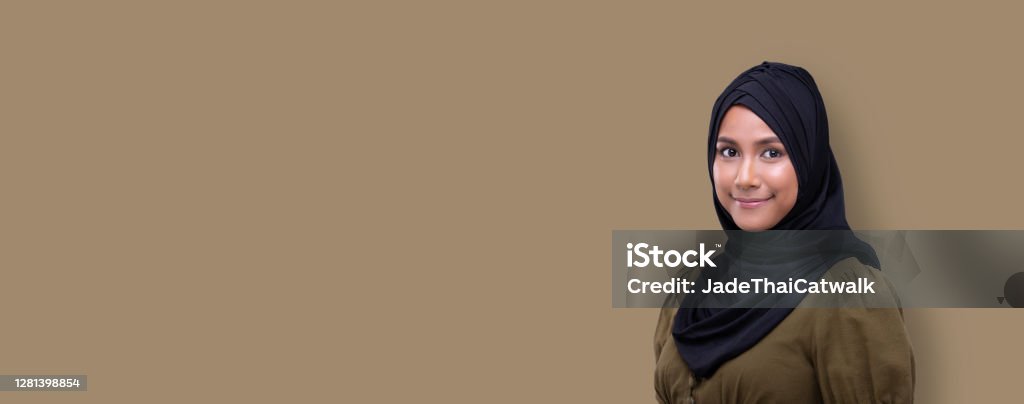 Fashion Portrait Profile Asian Woman fashionable item make up Muslim young woman wearing black hijab green clothes look at camera, she smile and happy with big eyes. beige yellow background isolated copy space banner 20-29 Years Stock Photo
