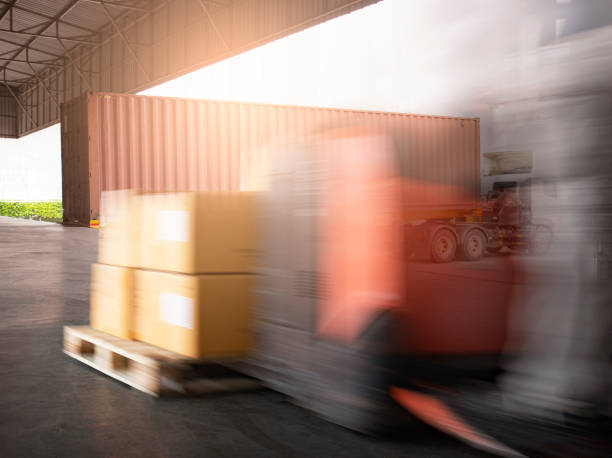 istock Speed motion blur of forklift unloading cargo boxes at the warehouse. Cargo boxes, Shipment, Freight truck and Warehousing. 1281399087