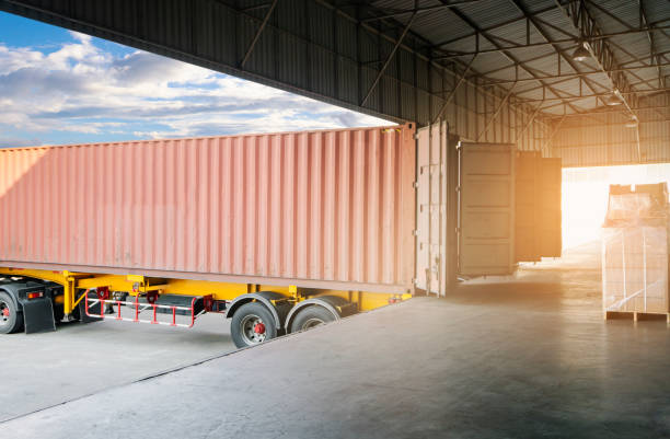 istock Cargo freight truck, Shipment boxes, Logistics and transportation. Trailer truck docking to load cargo at the warehousing. 1281399088