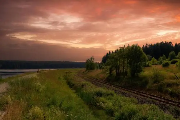 a landscape with railway line in the orange sunset