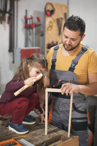 istock Father and daughter making wooden frame in workshop 1281400094