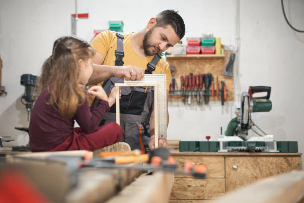 istock Father and daughter making wooden frame in workshop 1281403019