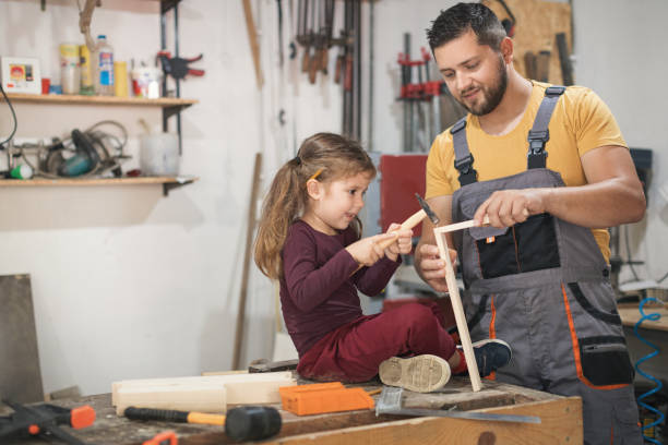 istock Father and daughter making wooden frame in workshop 1281403823