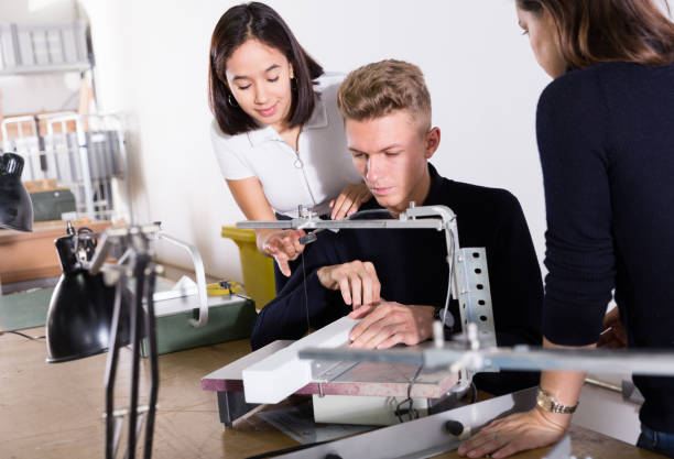 istock Female teacher controlling work of students on scroll saw 1281409278