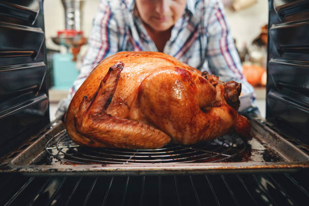 roasting turkey in the oven for holiday dinner - peru imagens e fotografias de stock