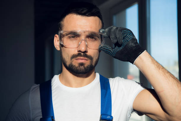 Close up, bearded craftsman wearing protective glasses stock photo