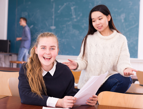 Delighted Schoolgirl And Chinese Girl Schoolmate Reading Notification Stock Photo Download Delighted Schoolgirl And Chinese Girl Schoolmate Reading Notification Stock Photo Download