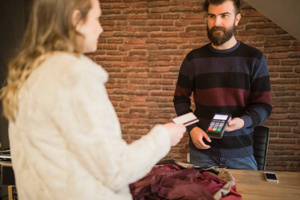 istock Employee in the store holding credit card reader and charging customer 1281412506