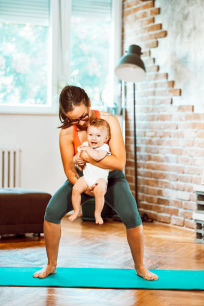istock Woman exercising at home with baby 1281413773