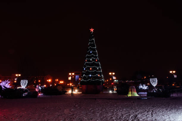 istock snowfall walk down the street past the dressed up festive Christmas tree and colored figures-multi-colored balls 1281413845