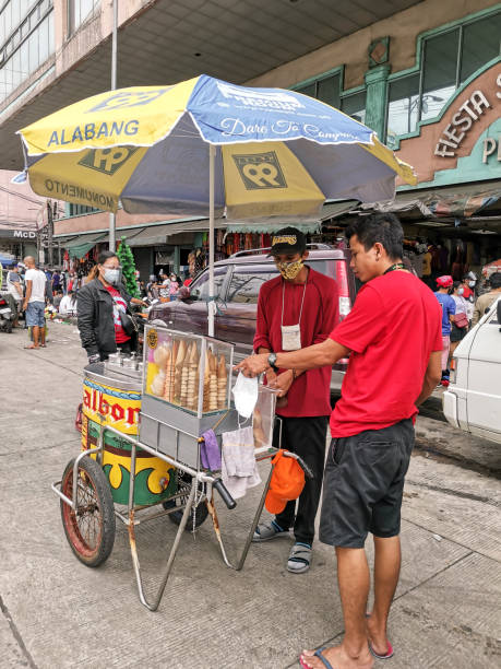 Divisoria, Manila, Philippines - A peddler selling sorbetes talks to his friend. Shot along Recto Avenue. Divisoria, Manila, Philippines - Oct 2020: A peddler selling sorbetes talks to his friend. Shot along Recto Avenue. divisoria market stock pictures, royalty-free photos & images