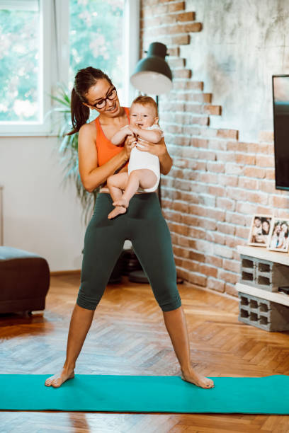 istock Woman exercising at home with baby 1281413893