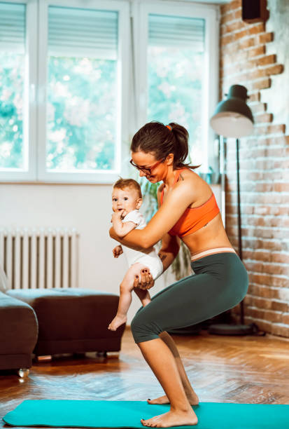 istock Woman exercising at home with baby 1281413895